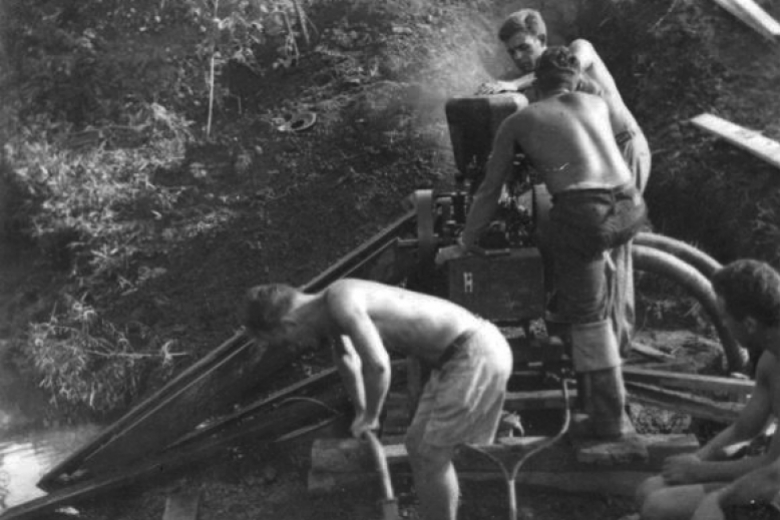 young men work with pipes and drilling equipment
