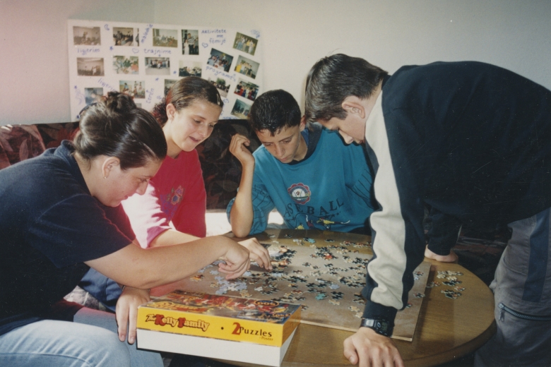 Four children work on a puzzle together.