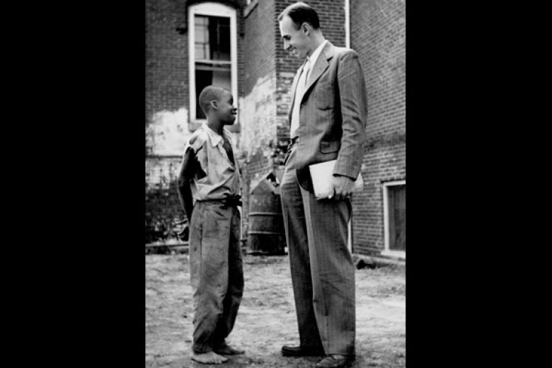 Young child talking with an adult social worker in a suit