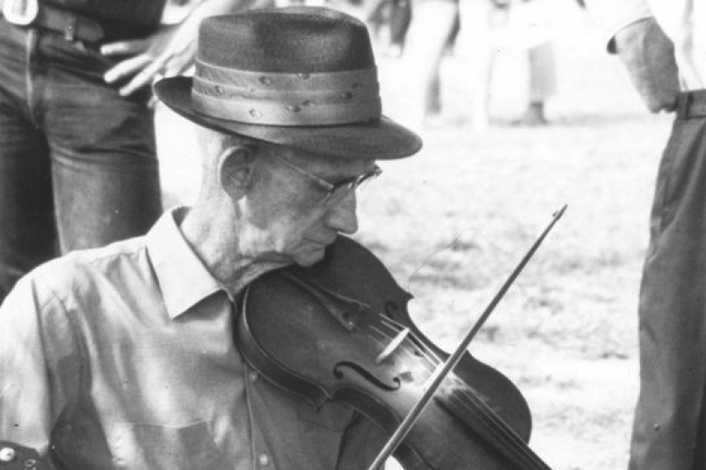 White-haired man plays fiddle