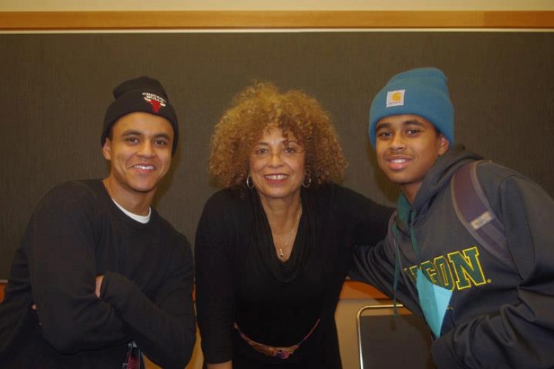 Two young men and a woman pose together for a photo.