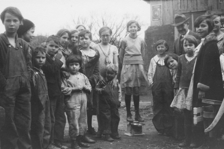 Group of children stand together outside.