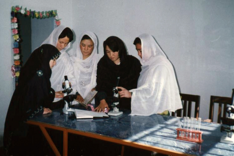 Five women working with microscopes and vials.